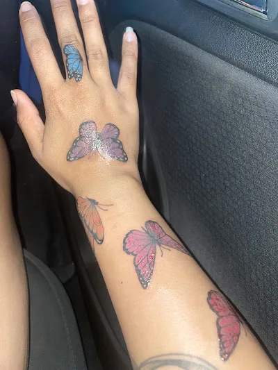 Small black and gray tattoos across the back of both hands