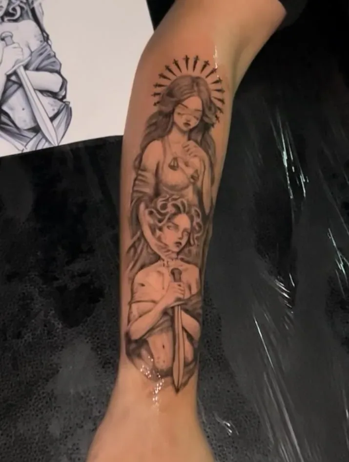 Black and gray arm tattoo of a woman's portrait with sun rays