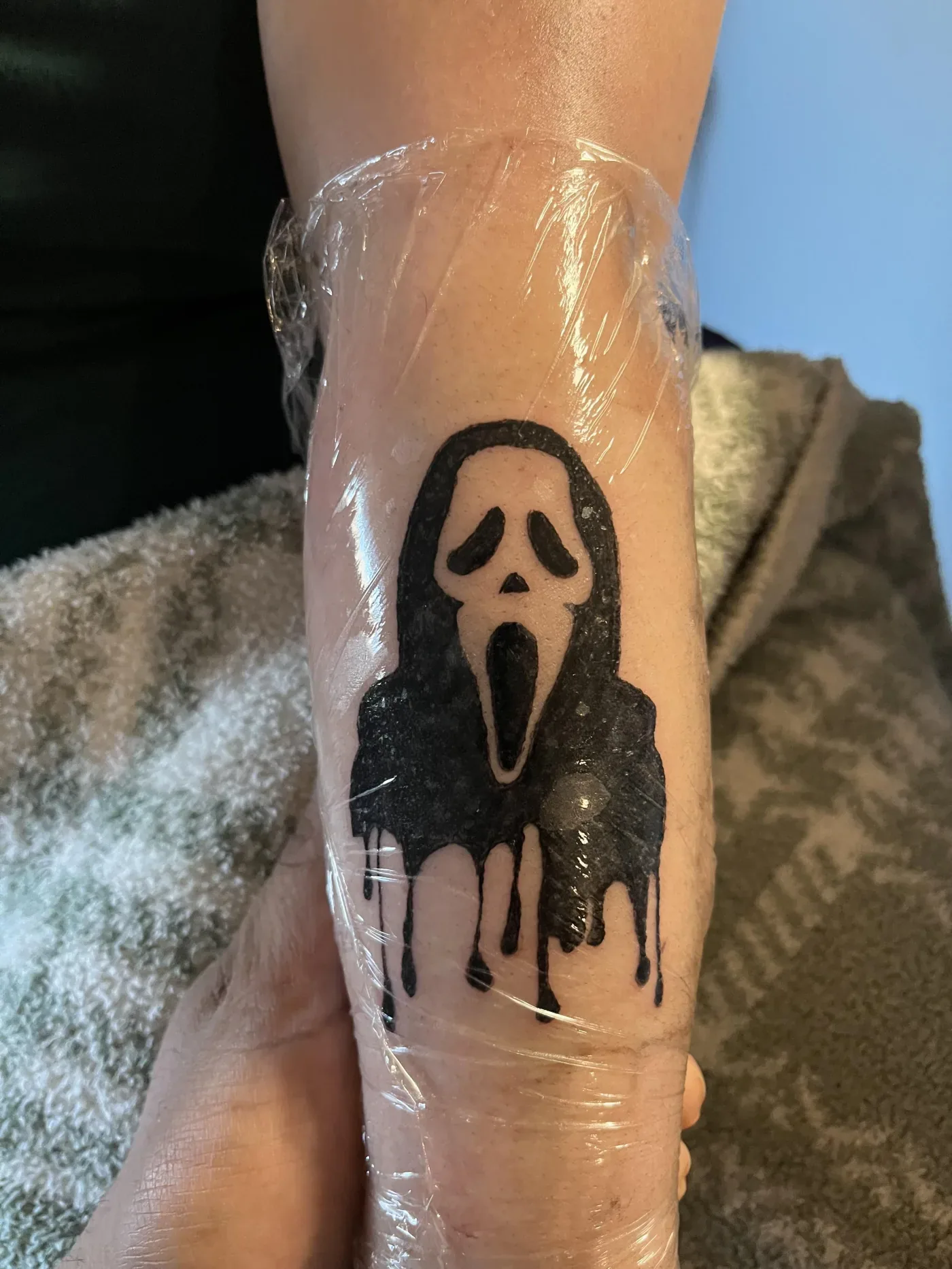 Ghostface character tattoo wrapped on a client's forearm after a session