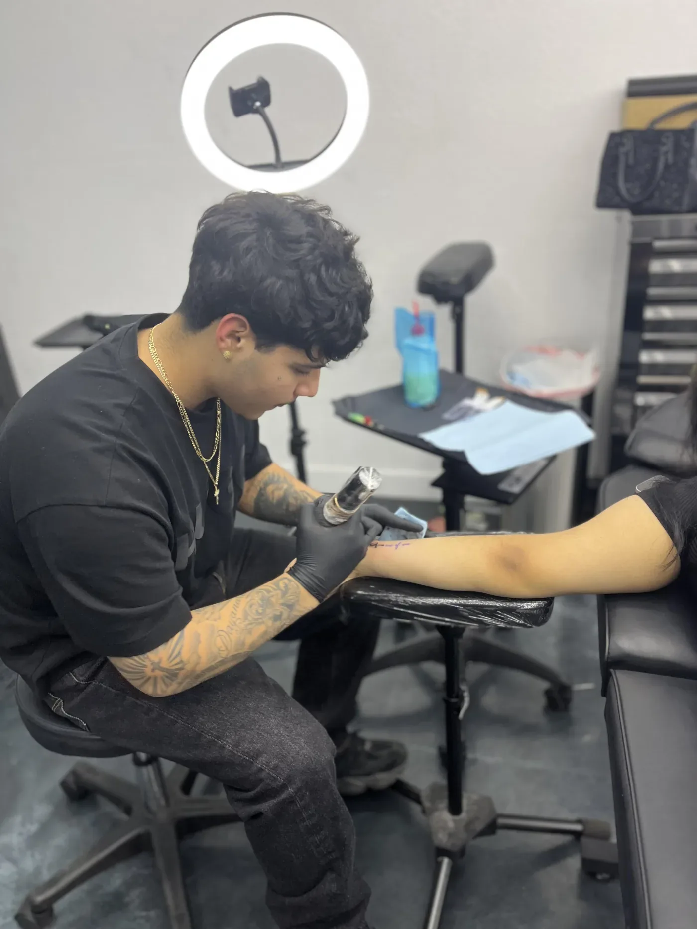 Artist working at a tattoo station inside InkSquad Studio
