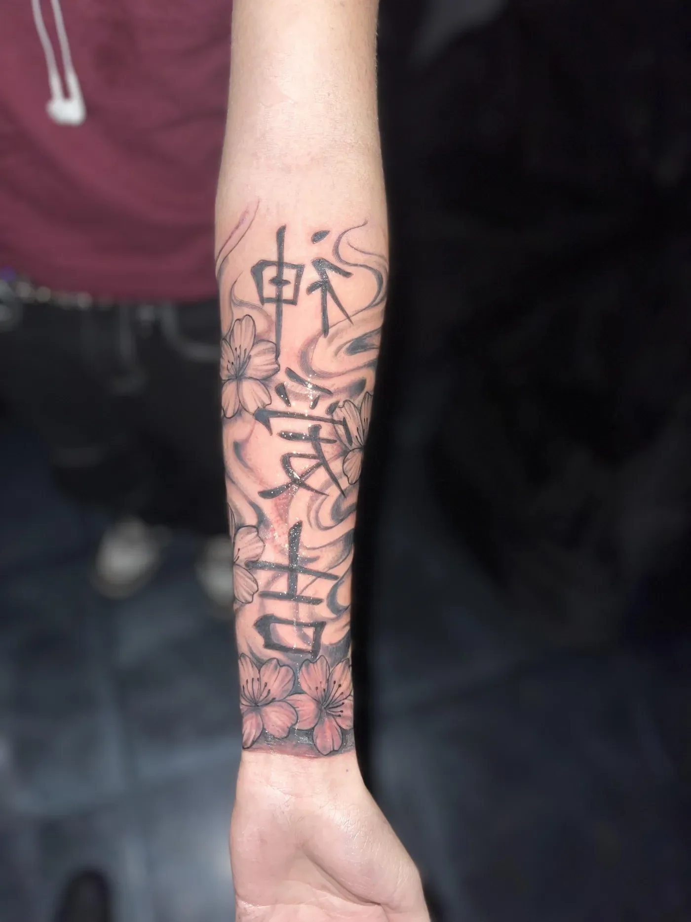 Script lettering tattooed down a client's forearm